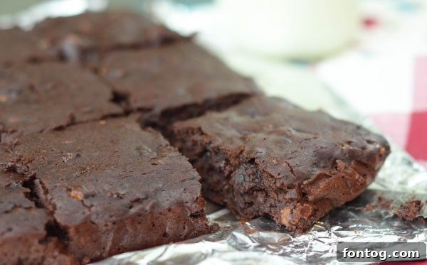 Black Bean Brownies - two square brownies on a white surface, one with a bite taken out