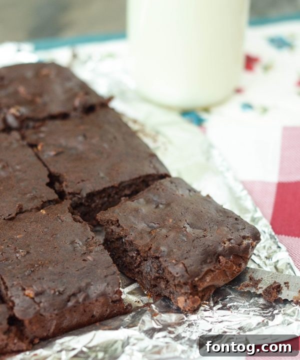Black Bean Brownies - a stack of three brownies with chocolate chips on a white plate