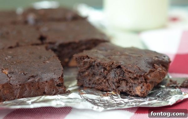 Black Bean Brownies - a close-up of a brownie with a fork on a white plate