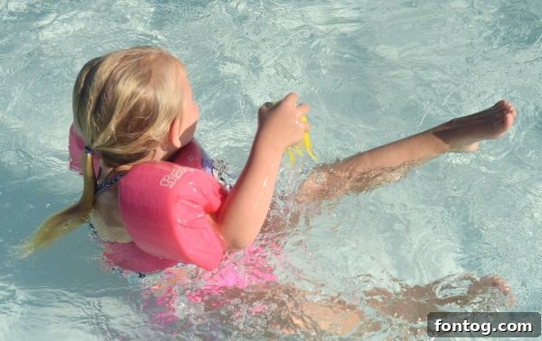 A close-up view of two Lil' Fishys toys actively swimming in pool water