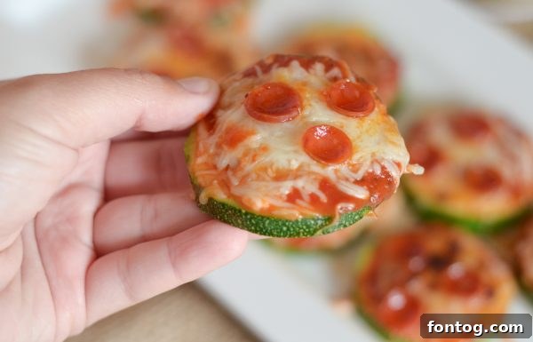 Freshly broiled Zucchini Pizza Bites cooling on a baking sheet, cheese perfectly melted.