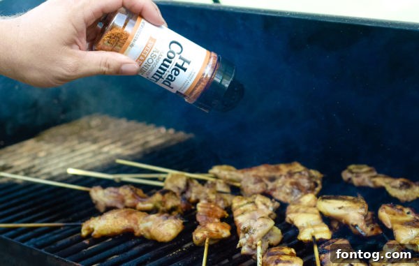 Zesty Grilled Chicken Skewers Gluten Free 3 Raw boneless, skinless chicken thighs being cut lengthwise on a cutting board, prepared for skewering.