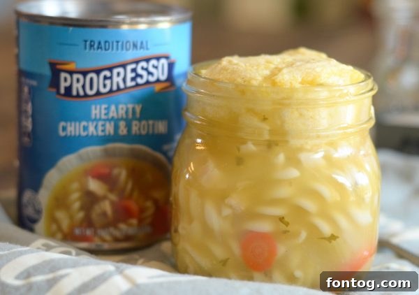 A hand holding a warm jar of cornbread topped soup, perfect for a quick lunch