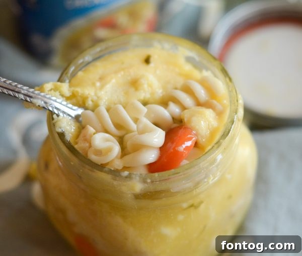 A single mason jar of cornbread topped soup, perfect for a grab-and-go meal