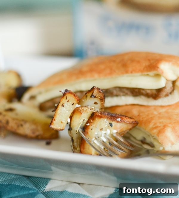 Platter of freshly Roasted Greek Potatoes, showing their golden brown exterior and a sprinkle of fresh herbs