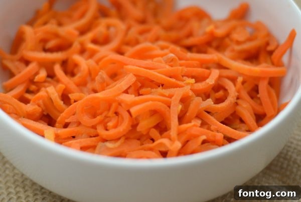 Green Giant Veggie Spirals in a pan, being drained after cooking, showcasing the convenience of preparation for these versatile vegetable noodles.