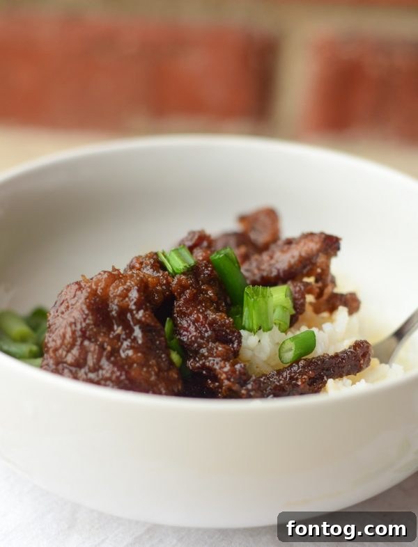Crispy Air Fryer Mongolian Beef served with rice and green onions