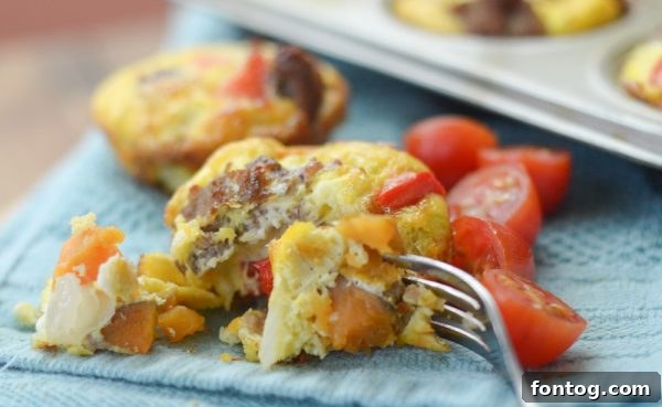 A close-up of baked Gluten-Free Sweet Potato & Sausage Egg Cups in a muffin tin.