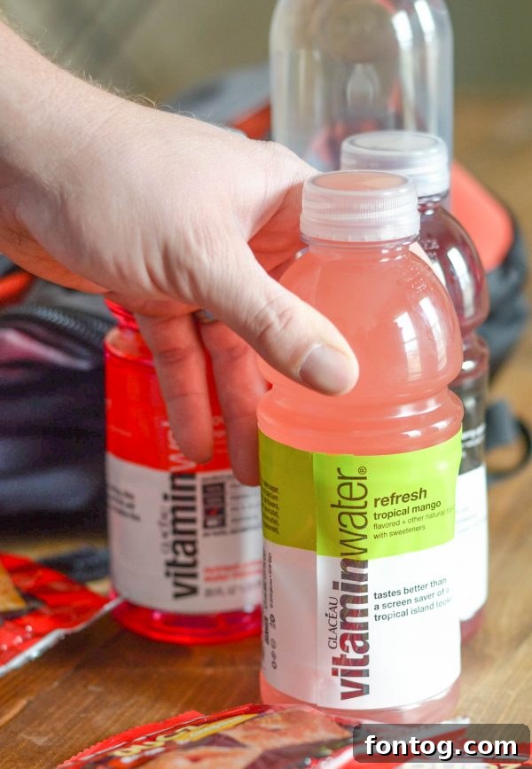 A well-packed cooler bag filled with smartwater, vitaminwater, and snacks, ready for a refreshing hike.