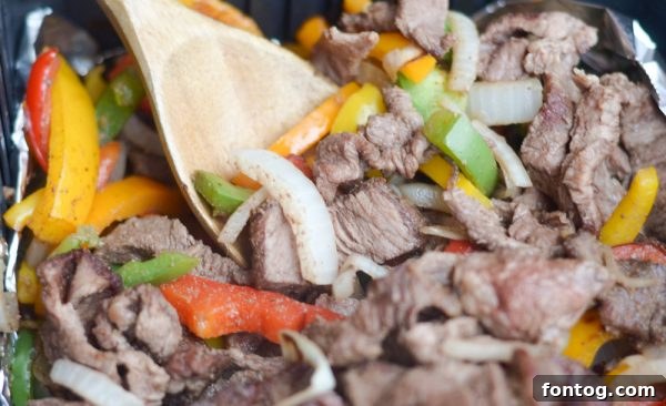 Weekly Meal Ideas Starting April 22nd 3 Crispy Air Fryer Steak Fajitas served with colorful peppers and onions.