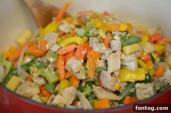 Sautéing fresh vegetables and chicken for a vibrant Pad Thai dish