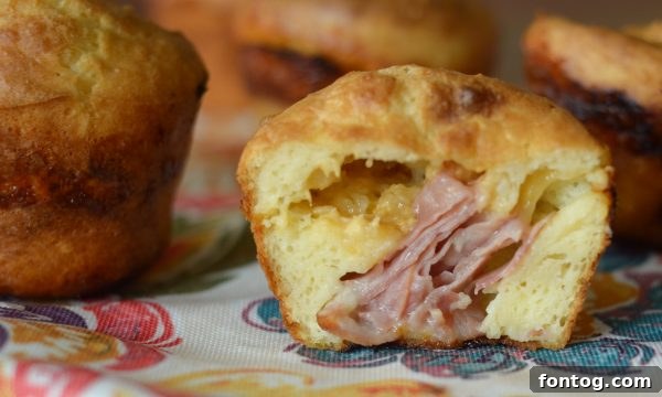Irresistible Ham and Cheese Popovers 9 A plate of several golden-brown ham and cheese stuffed popovers, arranged appealingly for serving.