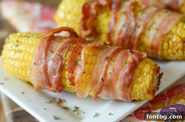 Three pieces of Air Fryer Bacon Wrapped Corn on the Cob on a plate