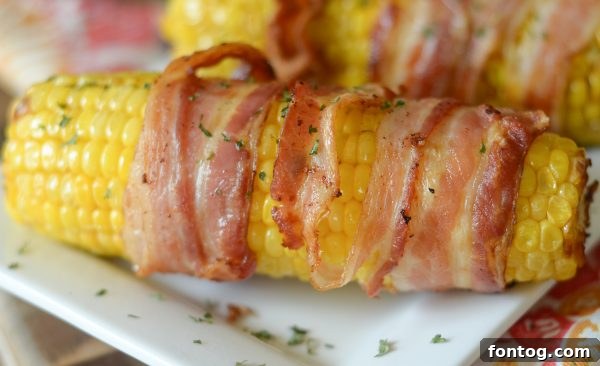 Close-up of Air Fryer Bacon Wrapped Corn on the Cob with melted bacon fat