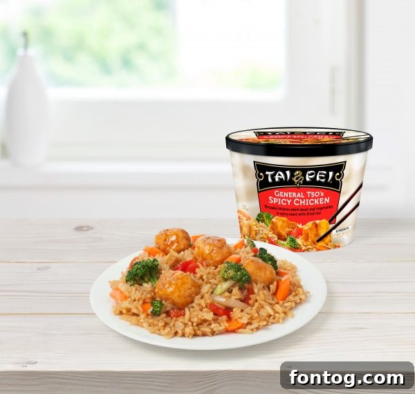 Tai Pei General Tso's Spicy Chicken, beautifully plated and ready to eat, with its convenient microwaveable packaging in the background.
