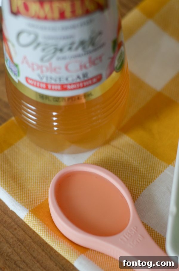 Close-up of Watermelon Pineapple Punch, garnished with fresh elderflower and mint, inviting a taste