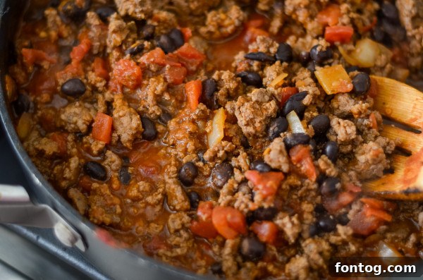 Layering the meat mixture and cheese in Gluten-Free Mexican Lasagna
