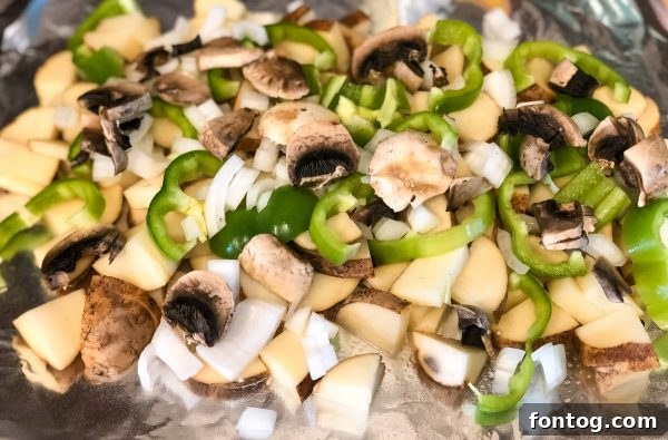 Your New Favorite Cheesy Grilled Potatoes 3 fresh ingredients for grilled cheesy potatoes including diced potatoes, bell pepper, mushrooms, onion, and a block of Velveeta cheese