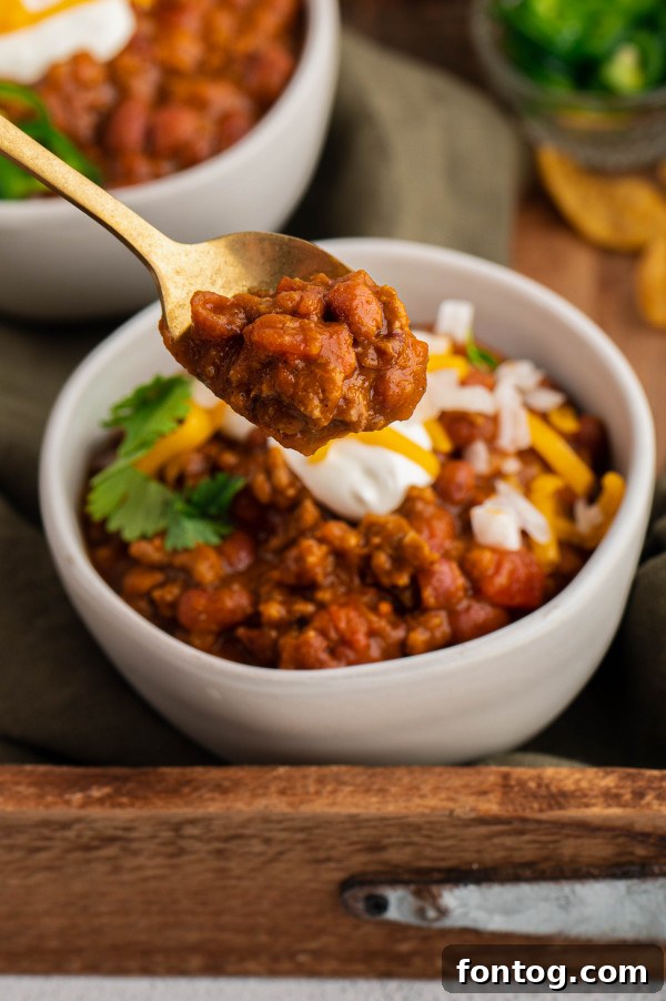 A beautifully presented serving of Instant Pot Pumpkin Chili with an assortment of toppings arranged artfully around it.