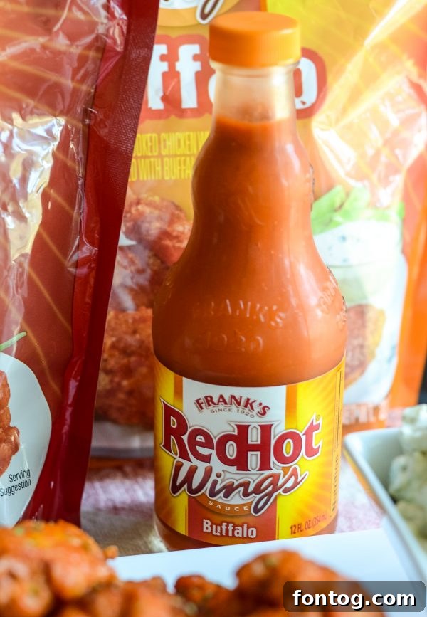 Three different varieties of Frank's RedHot Wings displayed on a wooden board.