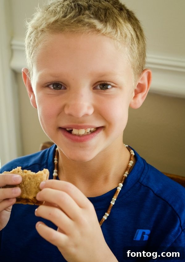 A hand holding a Betty Lou's Fruit Bar against a backdrop of outdoor activity, illustrating its on-the-go convenience.