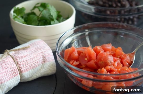 bowl of tomatoes with a towel next to it and a bowl of cilantro