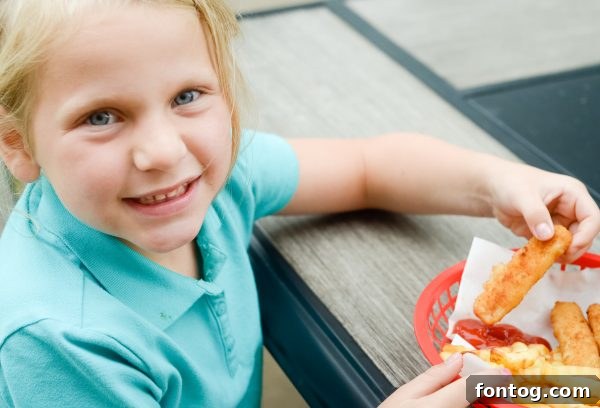 A child proudly presenting a tray of freshly baked Gorton's fish sticks, highlighting success in the kitchen.