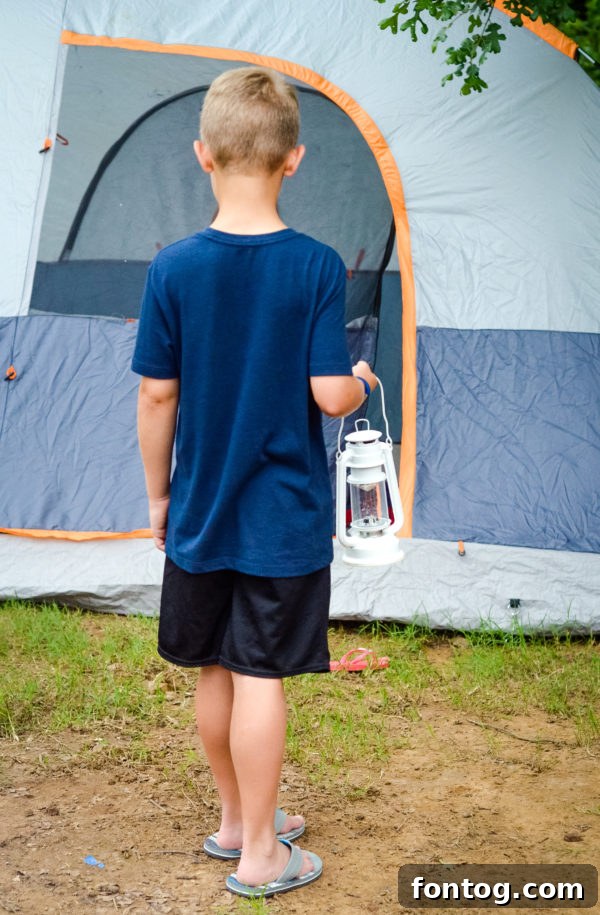 Backyard camping tent illuminated with string lights at night