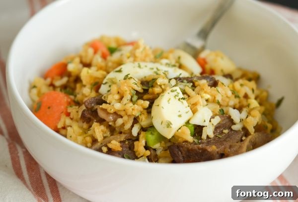 Crispy Air Fryer Beef Fried Rice, garnished with fresh herbs and hard-boiled eggs