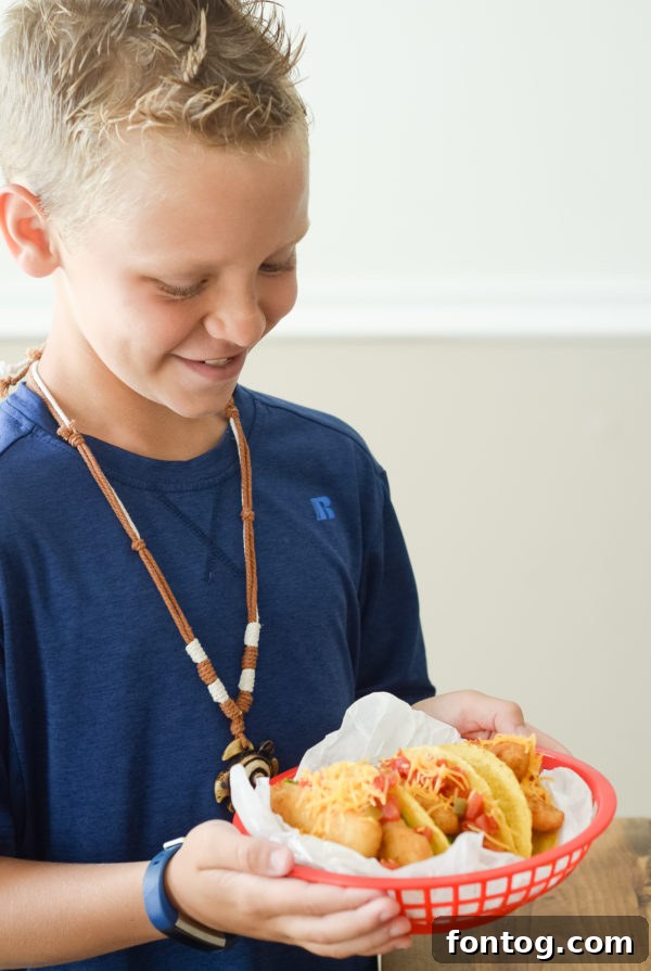 A young boy proudly holding a plate of crispy Gorton's Fish Sticks, ready for a simple summer meal