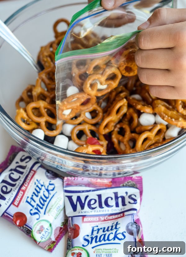 A bowl filled with fresh No-Bake Sweet & Salty Snack Mix, ready to be portioned.