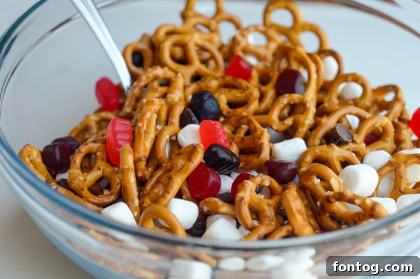 A close-up of Welch's Fruit Snacks being added to the mix, emphasizing their vibrant colors and real fruit appeal.