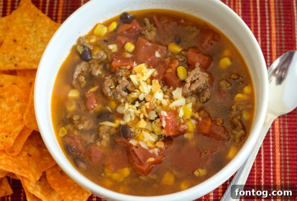 Ground beef browning in a Ninja Foodi pot with a spatula.