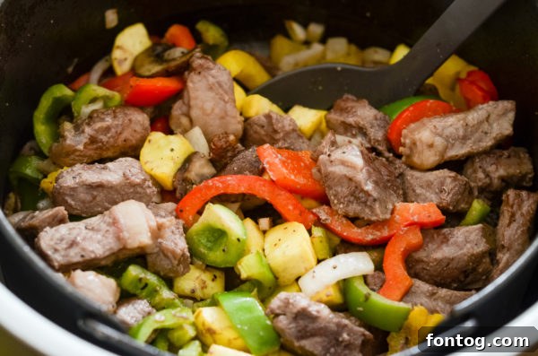 A close-up of a Ninja Foodi Steak and Vegetable Bowl with a fork.
