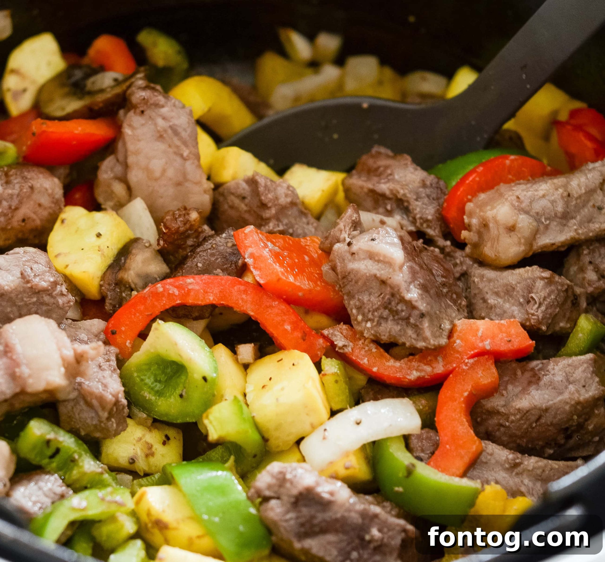A close-up of a Ninja Foodi Steak and Vegetable Bowl with a fork.