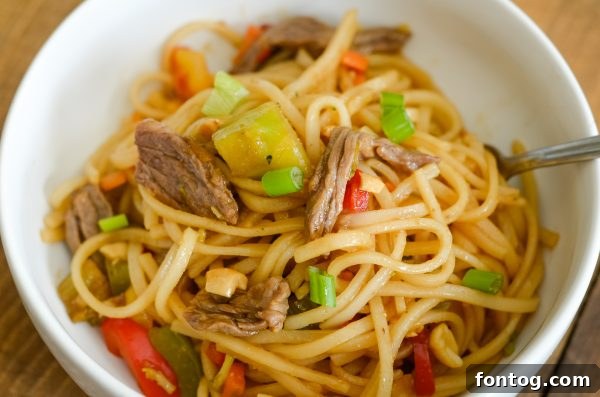 A vibrant and appetizing bowl of Easy Beef Pad Thai, garnished with fresh lime wedges and chopped peanuts, representing a delicious and accessible meal choice for weekly planning.