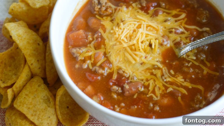 A warm bowl of Instant Pot Pumpkin Chili, richly colored and garnished with a dollop of sour cream and fresh cilantro.