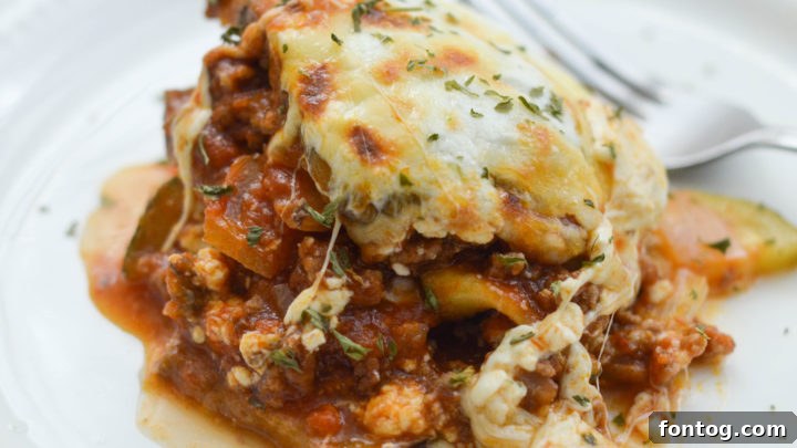 A generous slice of savory Eggplant Lasagna, revealing perfectly baked layers of cheese, tomato sauce, and tender eggplant.