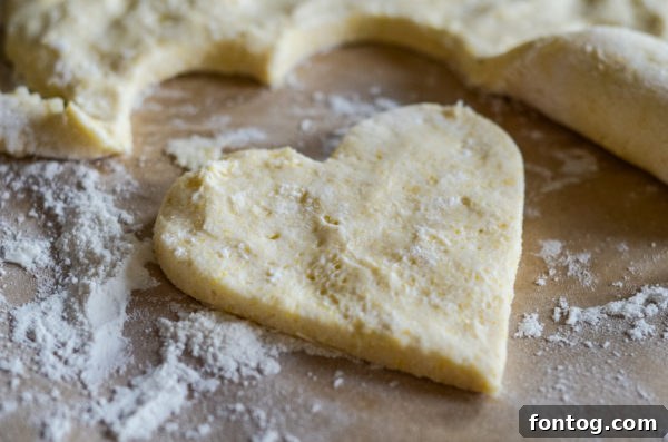 Raw gluten-free pizza dough being flattened on a surface