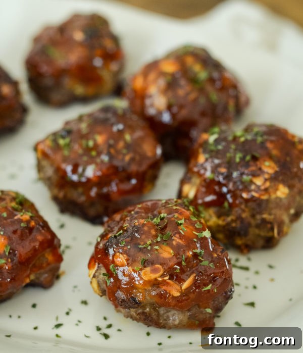 Tangy meatballs in a Ninja Foodi air fryer basket, garnished with parsley.
