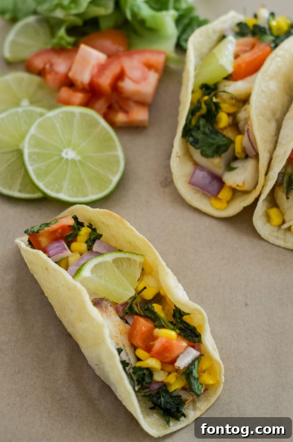 Effortless Weekly Meals March 8th Edition 2 A beautifully plated dish of Air Fryer Fish Tacos, garnished with fresh cilantro and lime, on a wooden board.