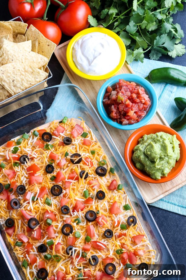Delicious Layered Taco Dip in a glass dish, ready to serve