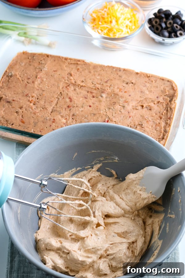 Close-up of a layered taco dip showing the creamy and fresh layers