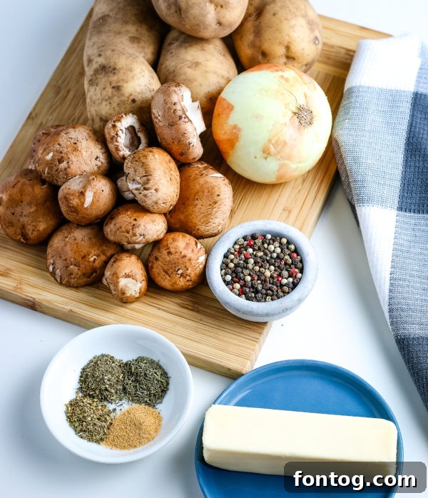 Fresh ingredients for grilled potatoes, including russet potatoes, onion, and herbs