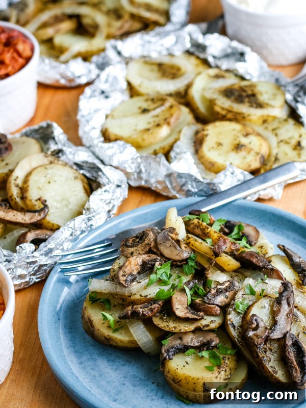 A serving of grilled potatoes in foil with melted butter and herbs