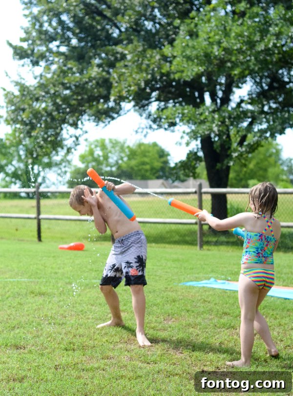 Backyard Bash: Your Family's Ultimate Game Night 2 Kids playing with water guns in the backyard, enjoying summer fun