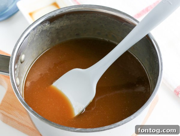 Velvety Gluten-Free Caramel Sauce 5 Hands stirring homemade caramel sauce in a saucepan