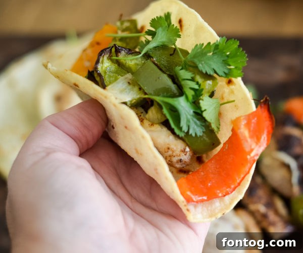 Platter of sliced grilled chicken fajitas with tortillas and lime wedges