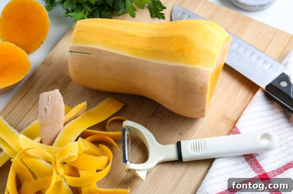 Whole and halved butternut squash on a wooden cutting board.