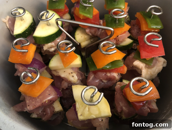 Close-up of seasoned chicken and vegetables ready for skewering.